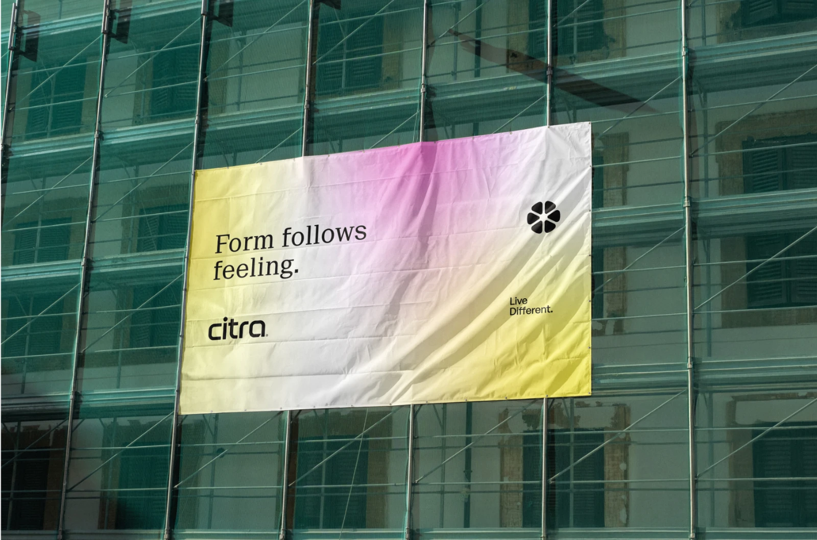 Citra’s Form follows feeling banner on a building wrapped in scaffolding.